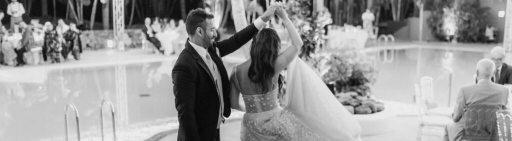 Novios en la cena de su boda en el Ritz-Carlton Abama, sentados bajo una estructura dorada y un techo de luces que simula un cielo estrellado.